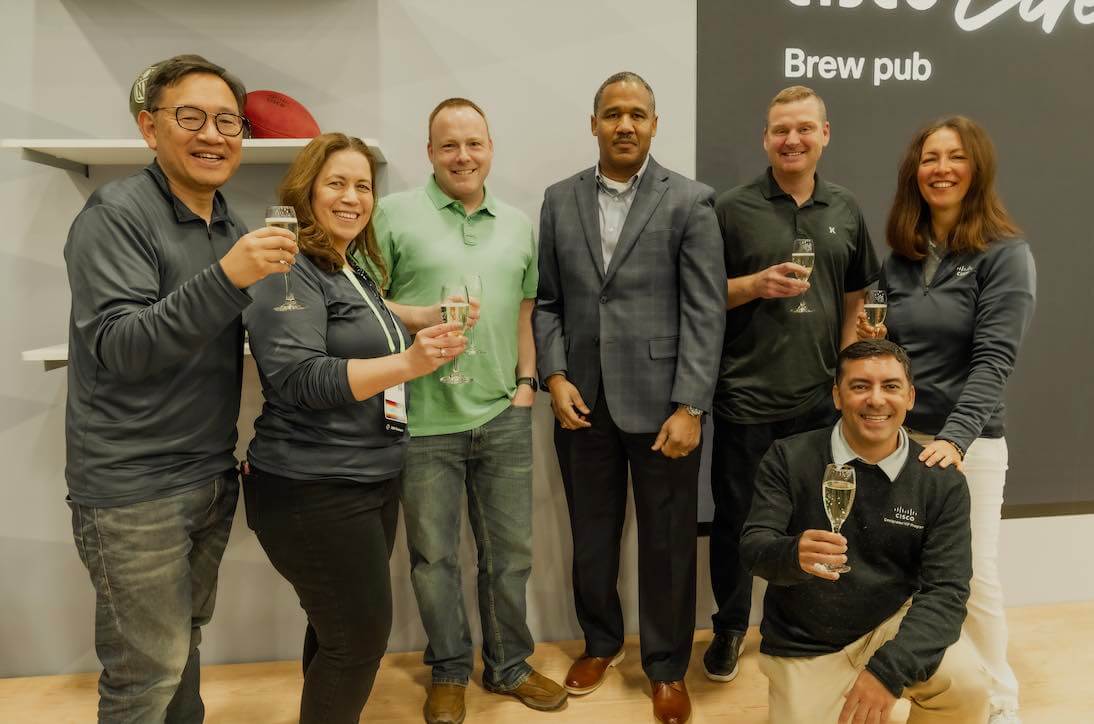Group of Cisco employees and customers celebrating with each other during a Cisco event